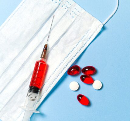 syringe and pills on blue background